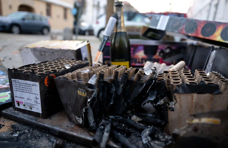 Eine Sektflasche und abgebrannte Feuerwerkskörper liegen nach der Silvesternacht auf einer Straße. — © Sven Hoppe/dpa
