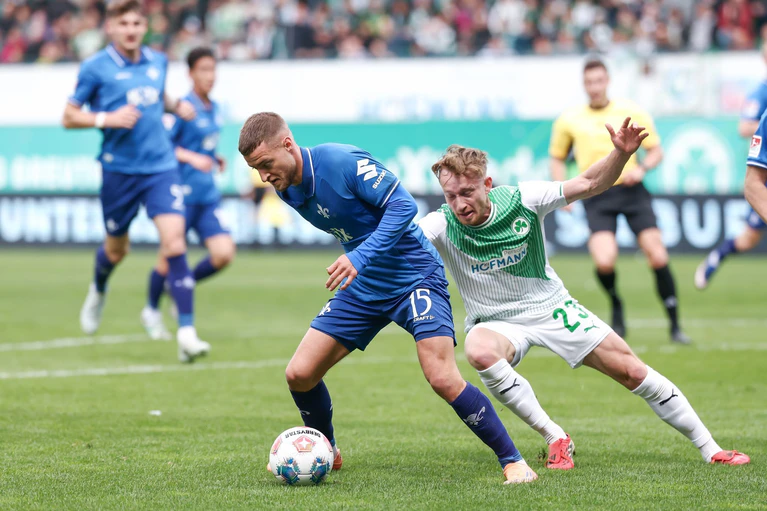 Darmstadts Fabian Nürnberger (links) und Jannik Dehm aus Fürth kämpfen um den Ball. — © Daniel Löb/dpa