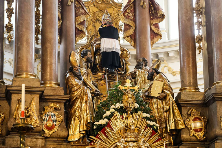 Pfarrer Daniel Lerch nimmt die so genannte Tiara ab.  — © Matthias Balk/dpa