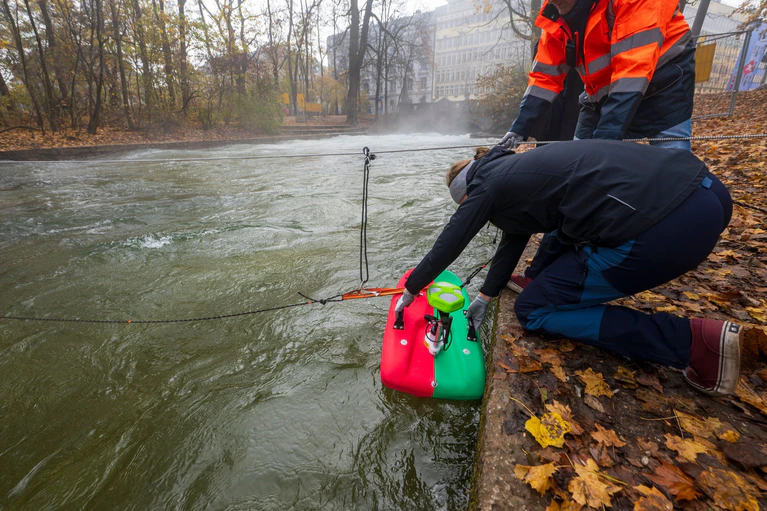 Mitarbeiter der Helmut-Schmidt-Universität aus Hamburg, Fachrichtung Wasserbau, vermessen mit speziellen Geräten den Strömungsverlauf und den Untergrund der Eisbachwelle im Englischen Garten. — © Peter Kneffel/dpa