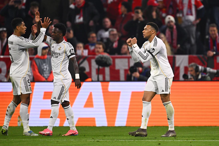 Reals Stürmerstar Kylian Mbappé jubelt mit Vinícius Júnior und Jude Bellingham (vr) nach seinem Tor zum 3:2.
 — © Tom Weller/dpa