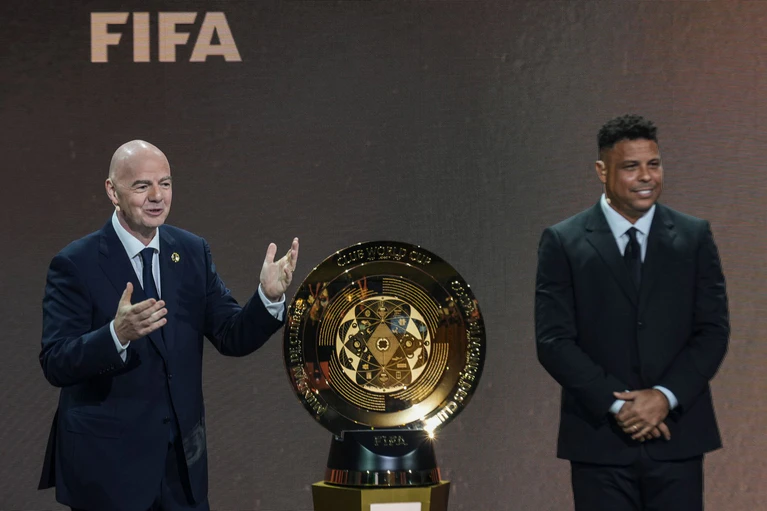 Gianni Infantino (l) und Ex-Profi Ronaldo präsentieren die Trophäe für den neuen Club-Weltmeister. — © Rebecca Blackwell/AP/dpa