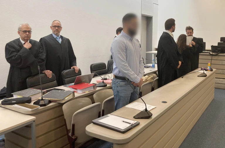 Von links nach rechts: Die Anwälte Klaus Wittmann und Thilo Bals, ein Angeklagter, Anwalt Johannes Makepeace, eine Angeklagte und Anwalt Alexander Stevens stehen zu Beginn der Fortsetzung ihres Prozesses im Gerichtsaal. Im Mordprozess um den Tod einer Doppelgängerin der angeklagten Frau stehen nun die Plädoyers der Verteidiger an. (Archivfoto) — © Sabine Dobel/dpa