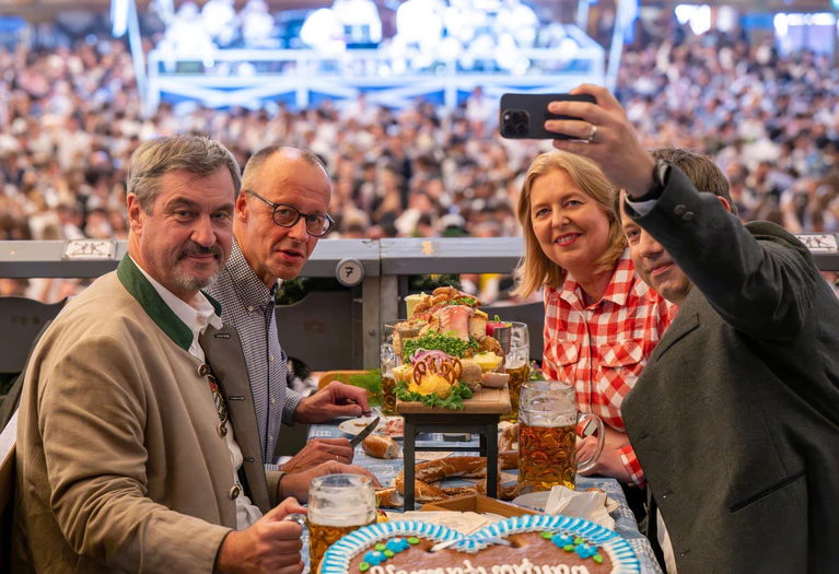 Gemeinsam mit CSU-Chef Markus Söder und den SPD-Parteivorsitzenden Bärbel Bas und Lars Klingbeil kam Merz ins Schottenhamel-Festzelt. — © Peter Kneffel/dpa