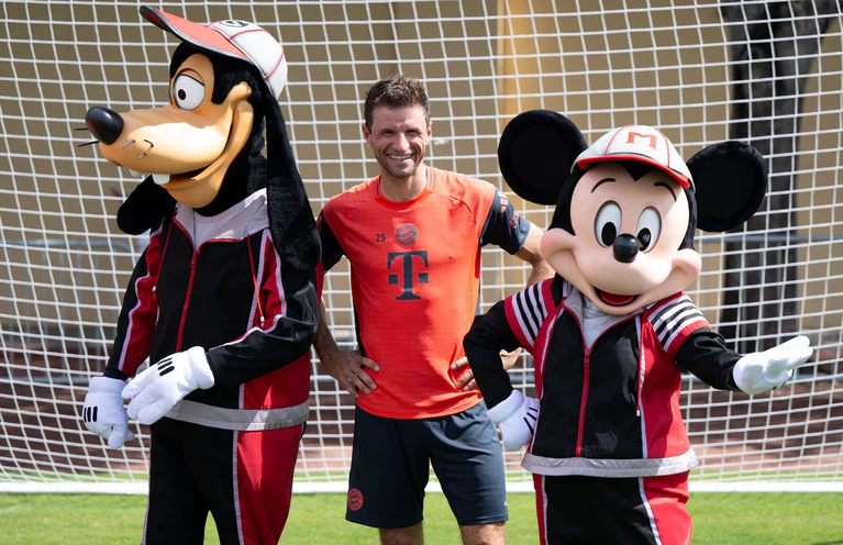 Thomas Müller mit Goofy und Micky Maus. — © Sven Hoppe/dpa