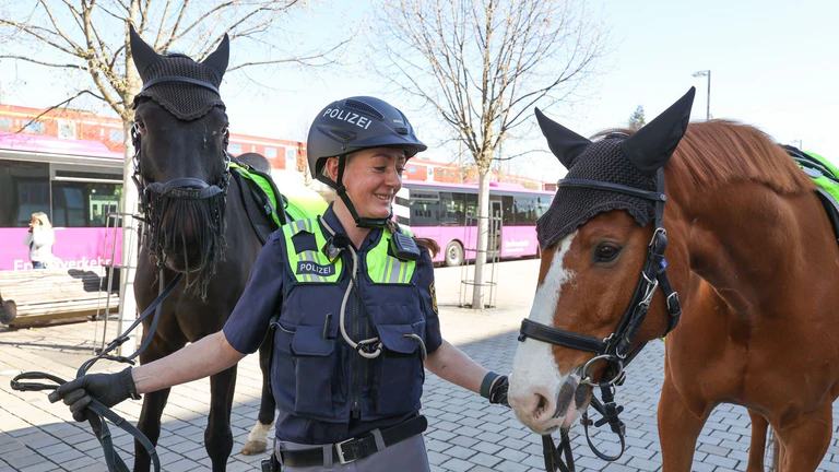 Polizistin Katharina Lorenz geht mit Remus (l) auf Streife.  — © Daniel Löb/dpa