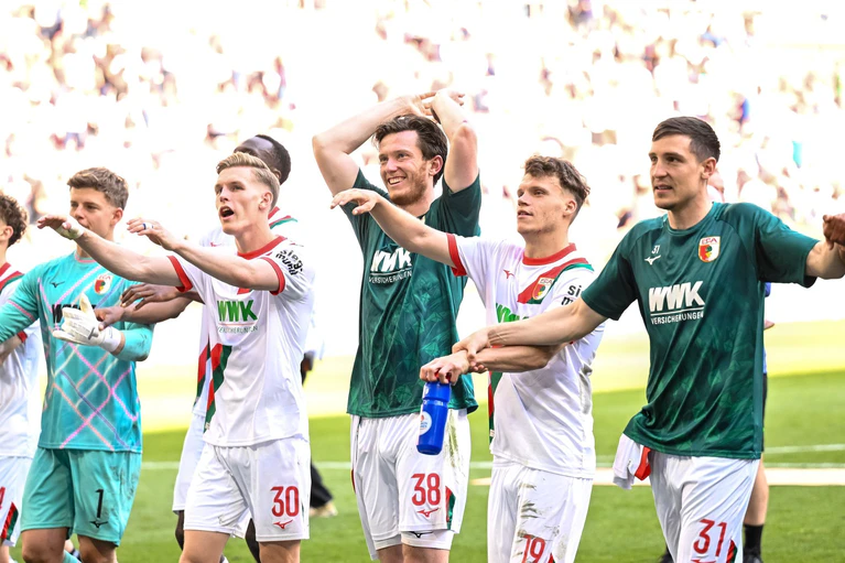 Ließen sich von den Fans feiern: Die Fußballer des FC Augsburg nach dem 3:1 über Gladbach. — © Harry Langer/dpa
