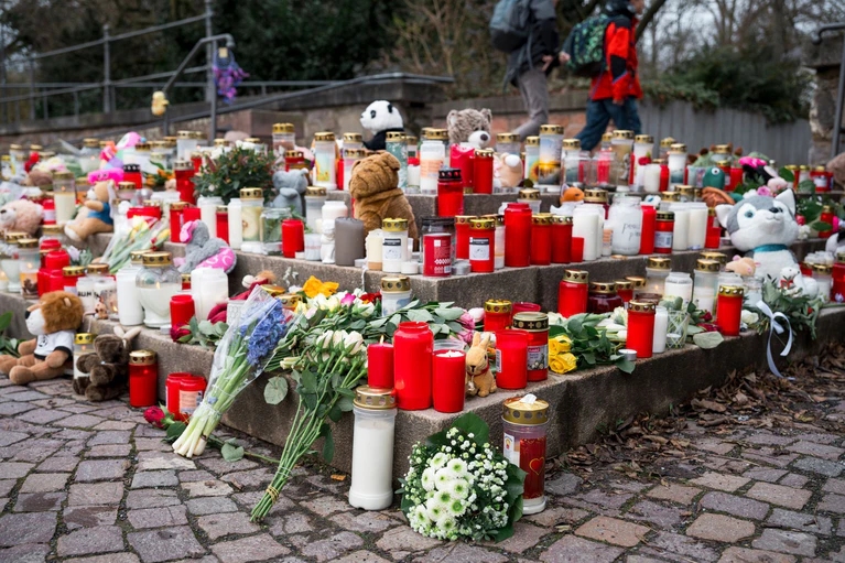 Viele Menschen kommen zum Tatort und legen Blumen und Kerzen ab. — © Daniel Vogl/dpa