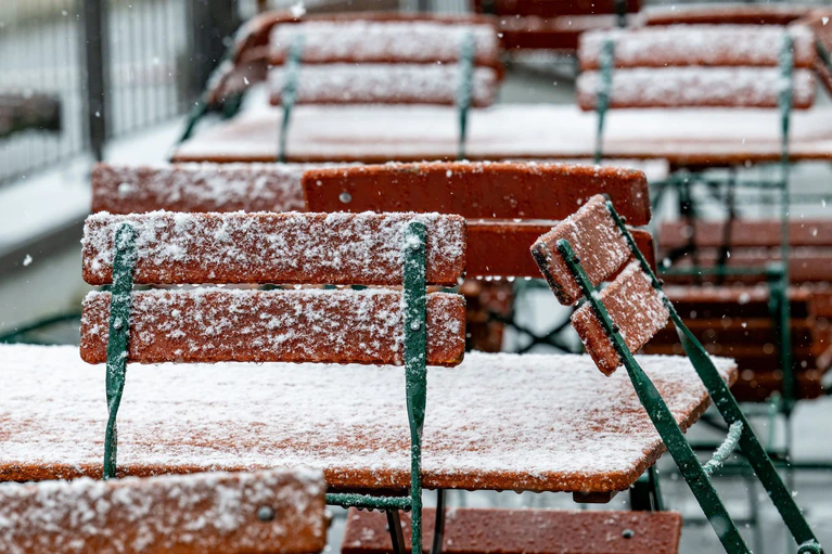 Der Schnee bedeckte am Großen Arber auch Tische und Stühle eines Restaurants. — © Armin Weigel/dpa