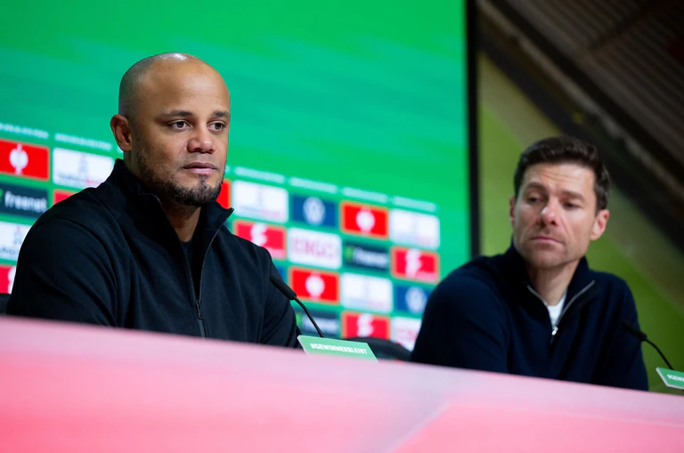 Verlierer Vincent Kompany (l) und Gewinner Xabi Alonso in der Pressekonferenz nach Leverkusens 1:0 in München. — © Sven Hoppe/dpa