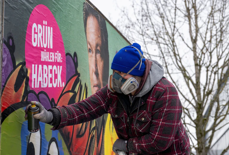 Im Auftrag der Grünen gestaltet der Künstler Bernd Imminger beschädigte Wahlplakate neu. — © Stefan Puchner/dpa