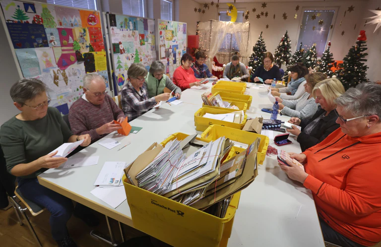 Freiwillige Mitarbeiter sortieren im Weihnachtspostamt Briefe an das Christkind aus aller Welt. (Archivbild) — © Karl-Josef Hildenbrand/dpa
