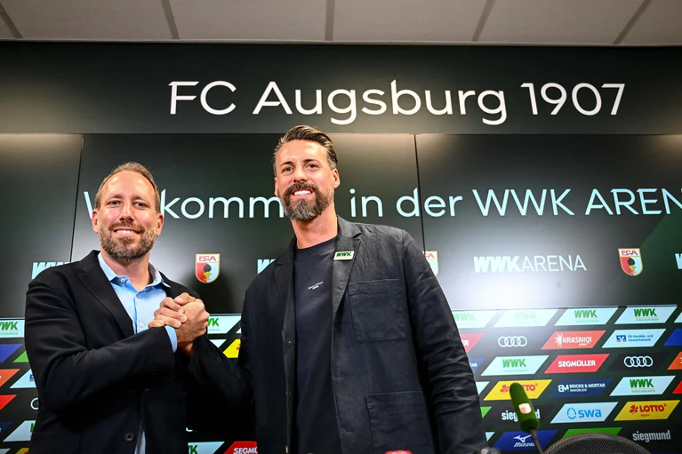 Das Projekt ist gescheitert: Augsburgs Geschäftsführer Ströll (l) und Wagner bei der Vorstellung des neuen Trainers im Juli. (Archivbild) — © Harry Langer/dpa
