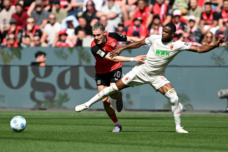 Florian Wirtz (l) leitet das 1:0 für Leverkusen ein. — © Federico Gambarini/dpa