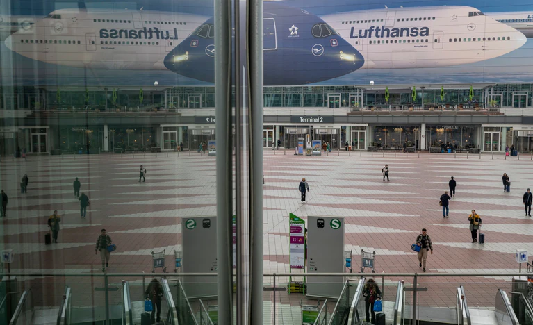 Passanten gehen am Morgen zum Flughafen München. Die Pilotengewerkschaft Vereinigung Cockpit hat für Montag und Dienstag zu Arbeitsniederlegungen bei der Lufthansa und mehreren Tochtergesellschaften aufgerufen. — © Peter Kneffel/dpa