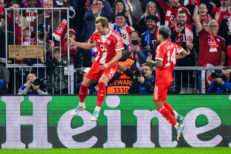 Harry Kane hebt nach seinem 3:1 ab zum Torjubel, rechts freut sich Luis Díaz.  — © Tom Weller/dpa