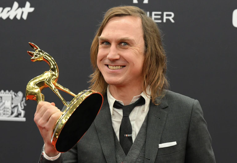 Lars Eidinger mit Bambi - er gewinnt in der Sparte Schauspieler national.  — © Felix Hörhager/dpa