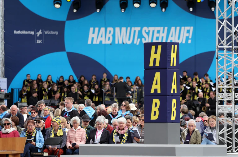 Das Motto des Katholikentags ist auf einer Bühne zu sehen.  — © Karl-Josef Hildenbrand/dpa