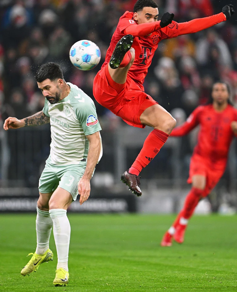 Rasanter Kampf um den Ball zwischen Jamal Musiala (r) und Bremens Anthony Jung. — © Sven Hoppe/dpa
