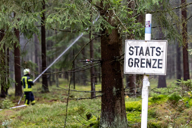 Flammen machen nicht an Staatsgrenzen Halt - die Einsatzkräfte ebenso nicht. — © Daniel Karmann/dpa