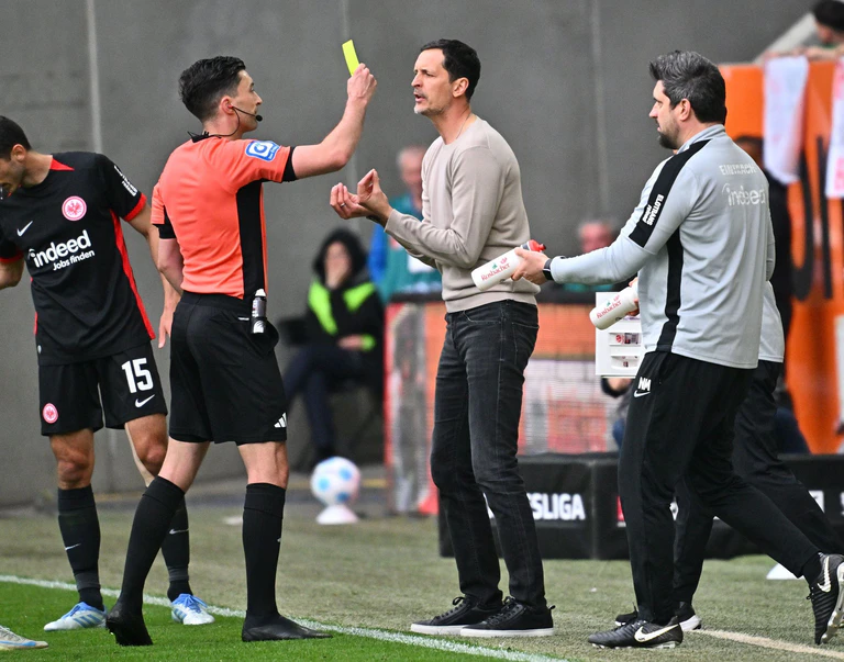 Aufreibender Tag am Spielfeldrand: Frankfurts Trainer Dino Toppmöller (r) bekommt von Schiedsrichter Florian Badstübner die Gelbe Karte gezeigt. — © Jan-Philipp Strobel/dpa