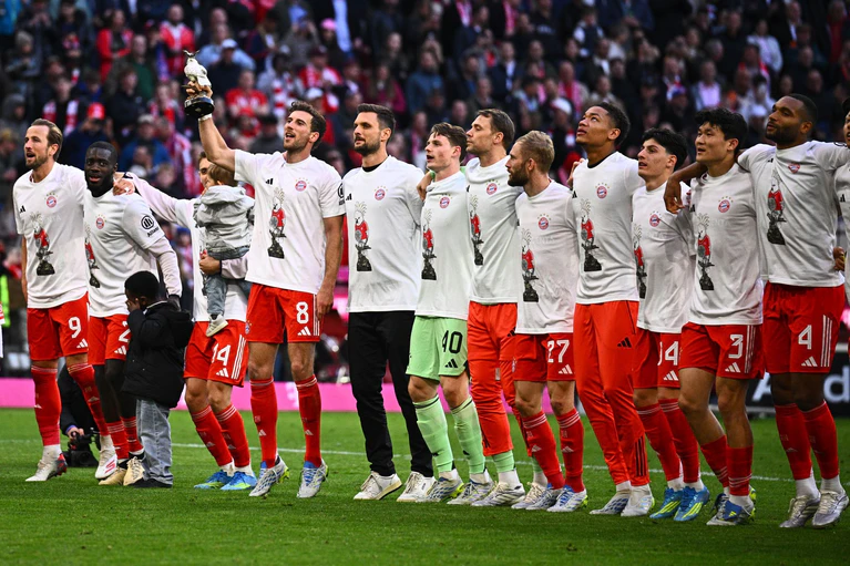Die Bayern-Profis feiern den Titel auf dem Rasen. — © Tom Weller/dpa