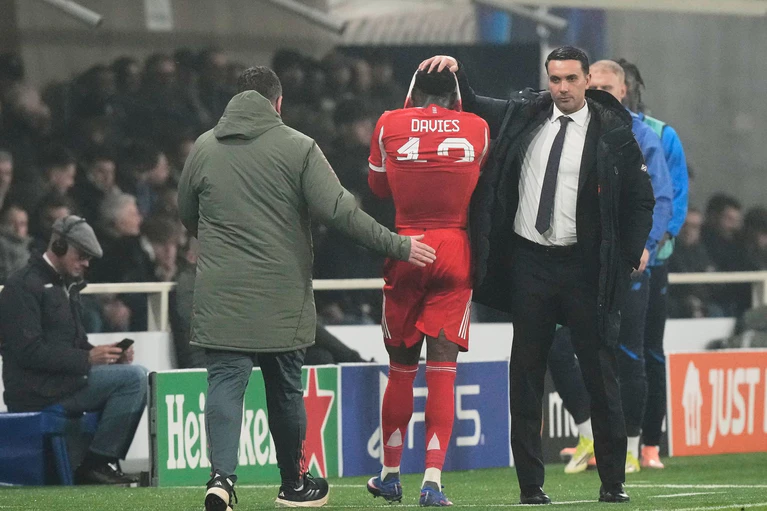 Atalanta-Trainer Raffaele Palladino (r) tröstet beim Hinspiel in Bergamo den verletzt ausgewechselten Bayern-Profi Alphonso Davies. (Archivbild) — © Luca Bruno/AP/dpa