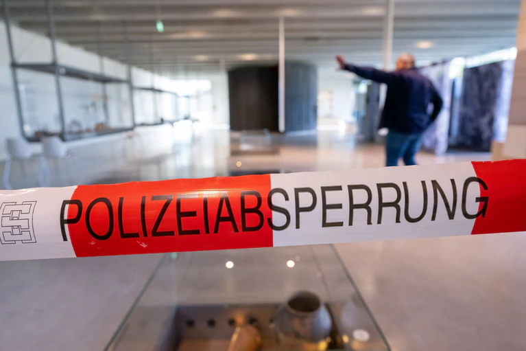 Ein Polizei-Absperrband hängt im Ausstellungsraum des Kelten Römer Museum. Einbrecher haben im oberbayerischen Manching einen mehrere Millionen Euro teuren Goldschatz aus der Keltenzeit erbeutet. (Archivbild) — © Peter Kneffel/dpa
