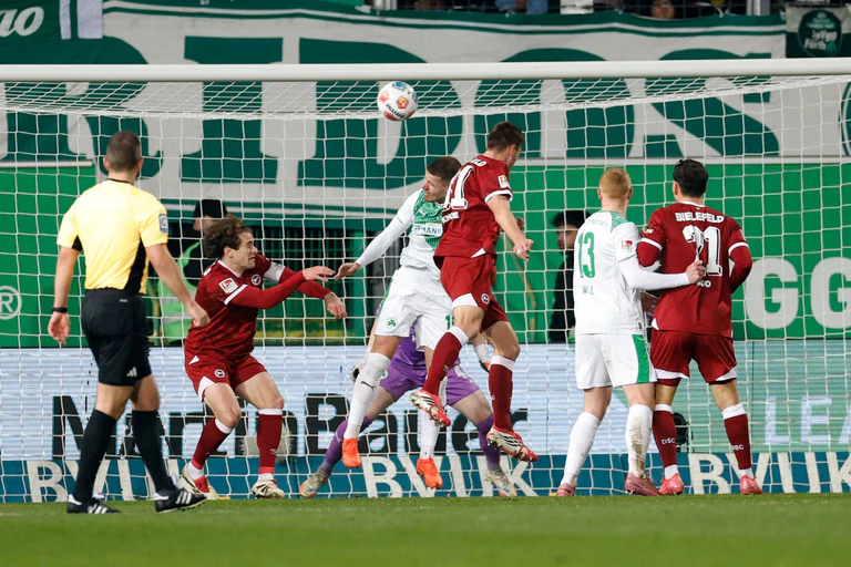 Ein ehemaliger Nürnberger trifft in Fürth: Robin Koche (M) köpft das 1:1 für die in Rot gekleideten Bielefelder. — © Heiko Becker/dpa