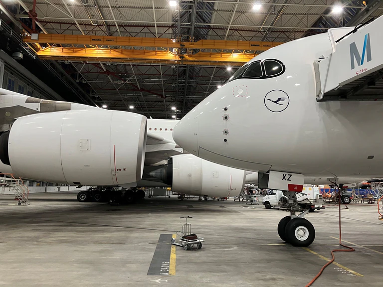 Die Nase des nagelneuen Airbus A350-900 "Solingen" Airbus A350 der Lufthansa im Wartungshangar am Münchner Flughafen. Die Maschine sollte nach der letzten Überprüfung durch die Techniker zu ihrem ersten kommerziellen Flug mit Passagieren an Bord nach Indien starten. Im Hintergrund die Triebwerke eines Airbus A380. — © Carsten Hoefer/dpa