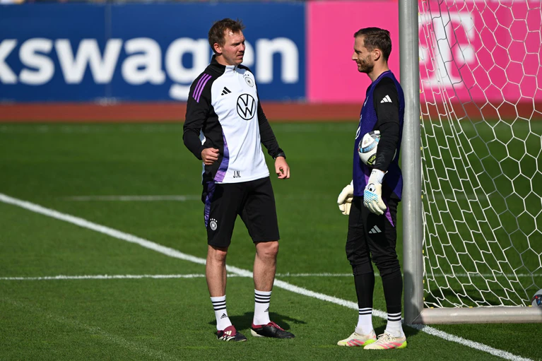 Bittere Nachricht für Oliver Baumann: Julian Nagelsmann (l) im Gespräch mit dem Hoffenheimer Torwart bei einer Trainingseinheit. (Archivbild) — © Federico Gambarini/dpa