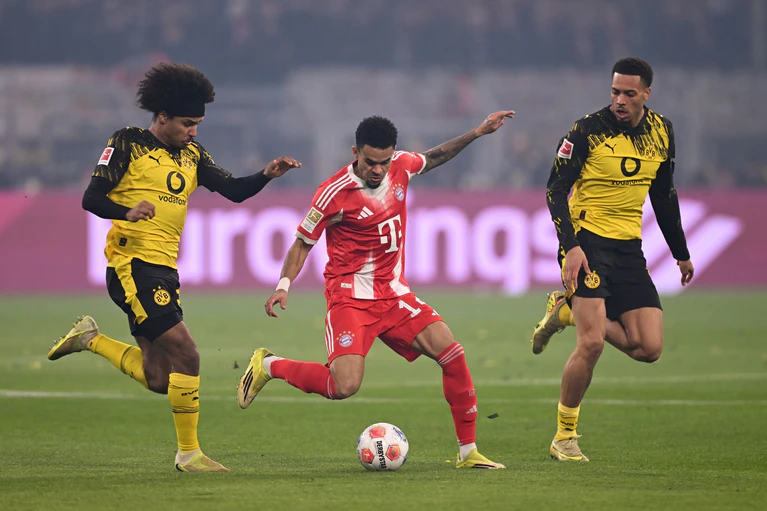 Luis Díaz umzingelt von zwei Dortmundern. — © David Inderlied/dpa