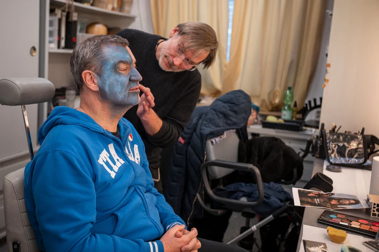 Maskenbildner Dirk Hirsch (r) weiß: Die blaue Schminke im Gesicht des Ministerpräsidenten darf nicht aussehen wie Make-up. — © Daniel Vogl/dpa