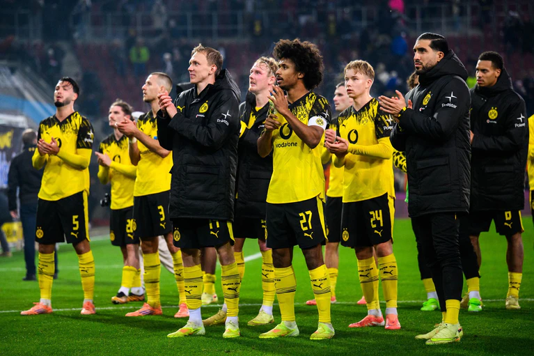 Hauptsache gewonnen: Dortmunds Spieler nach dem 1:0 in Augsburg vor ihren mitgereisten Fans.  — © Tom Weller/dpa