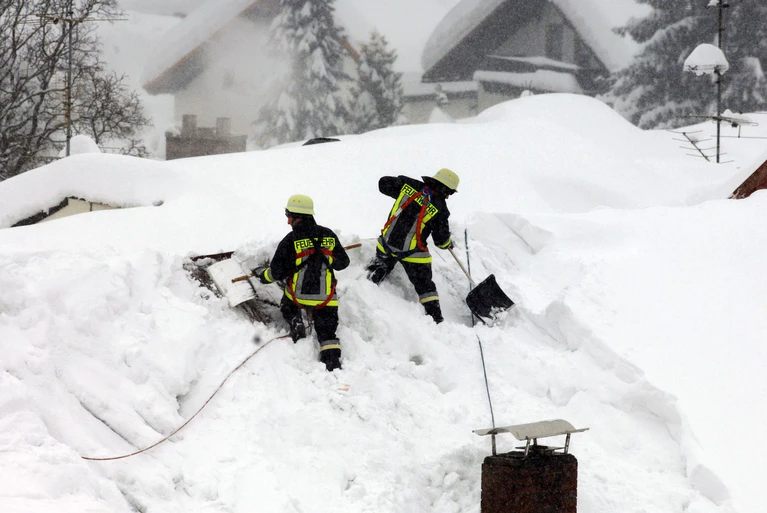 Feuerwehrmänner schaufelten Schnee von den Dächern. (Archivbild) — © Armin Weigel/dpa