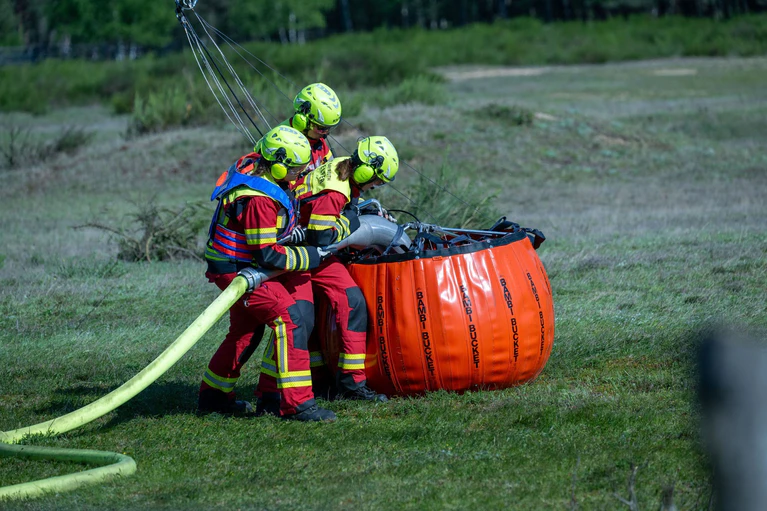 Nach Ausbruch des Waldbrandes wurden Säcke mit Löschwasser für die eingesetzten Hubschrauber gefüllt. (Archivbild) — © Pia Bayer/dpa