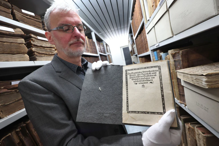 Christoph Engelhard, Stadtarchivar von Memmingen, zeigt im Archiv eine Druckausgabe der «Zwölf Artikel» aus dem Jahr 1525. — © Karl-Josef Hildenbrand/dpa