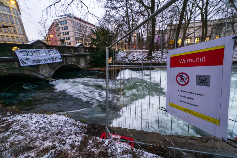 Warnschild und Protestplakat.  — © Peter Kneffel/dpa