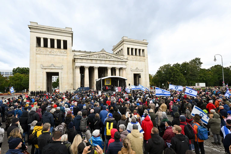 Menschen stehen bei der Kundgebung «Dach gegen Hass» gegen Antisemitismus am Königsplatz in München. — © Tobias Hase/dpa