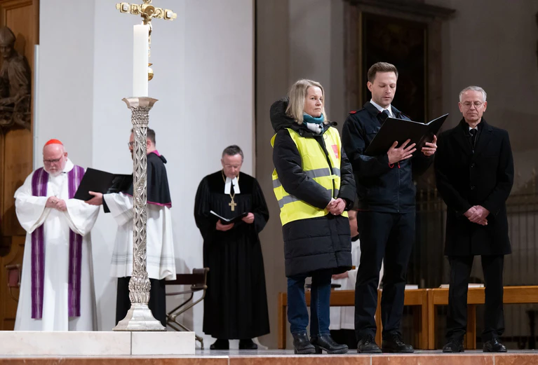 Claudia Weber, Geschäftsführerin der Gewerkschaft Verdi, Tobias Scheller, Feuerwehr München, und Bernd Fuchs, Werksleiter Stadtentwässerung, nehmen im Liebfrauendom an einem ökumenischen Gottesdienst mit interreligiöser Beteiligung für Betroffene, Angehörige und Einsatzkräfte des Anschlags in München teil. — © Sven Hoppe/dpa-Pool/dpa