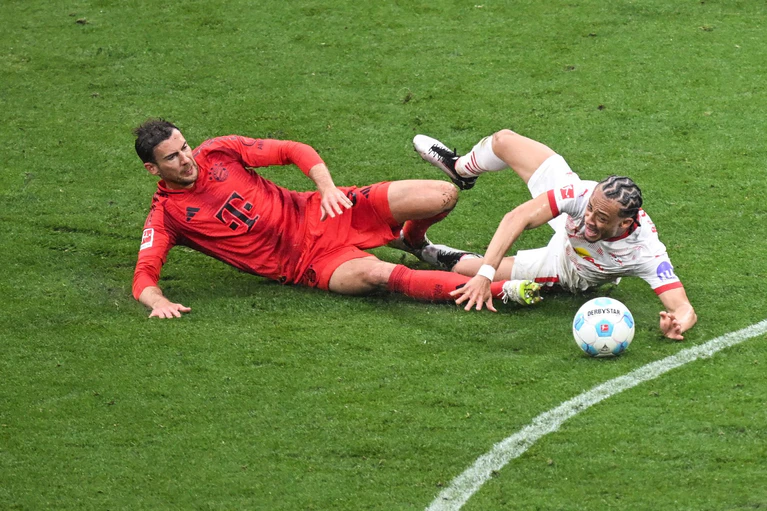 Leon Goretzka (l) und Leipzigs Xavi Simons kämpfen um den Ball. — © Hendrik Schmidt/dpa