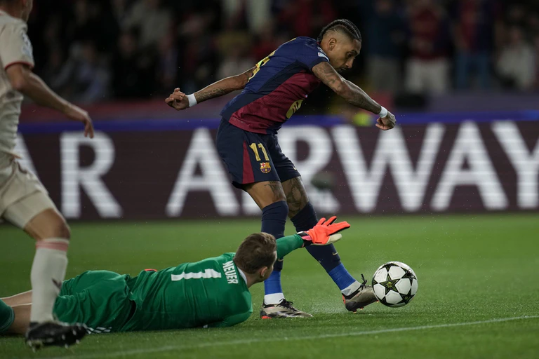 Manuel Neuer am Boden, hier beim ersten der drei Tore von Angreifer Raphinha (r) beim 1:4 in Barcelona.  — © Emilio Morenatti/AP