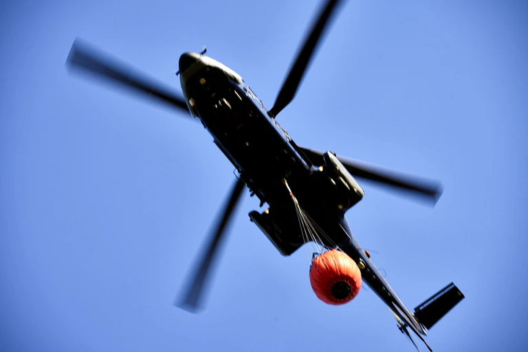 Löschhubschrauber kreisen weiterhin über die abgebrannte Fläche. (Symbolbild) — © Michael Ukas/TNN/dpa