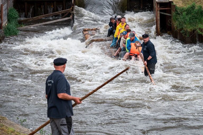 Ein Flößer steuert das Floß mit einem Floßhaken durch die Schleuse und den Fluss entlang. — © Daniel Vogl/dpa