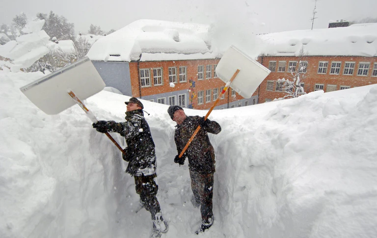 In Zwiesel mussten 2006 Bundeswehrsoldaten Schnee vom Dach einer Schule schaufeln. (Archivbild) — © Armin Weigel/dpa