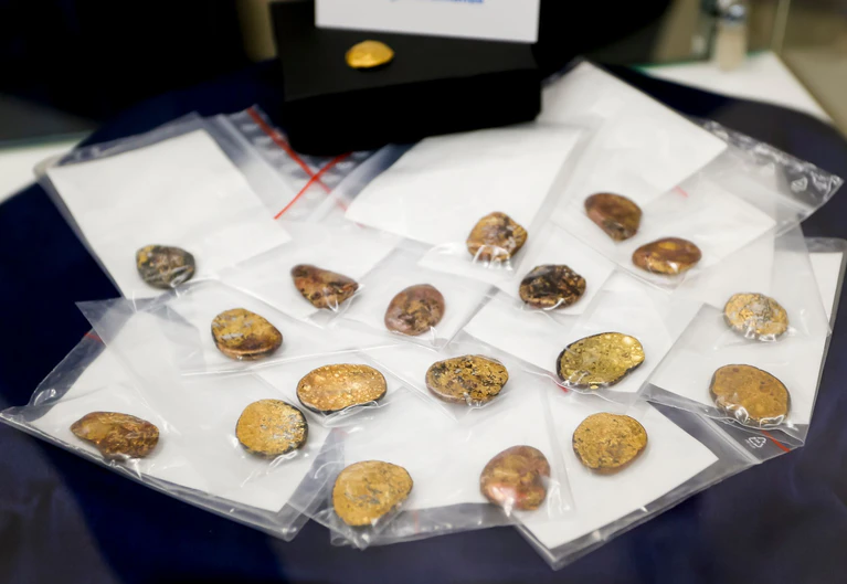 Sichergestellte Münzklumpen werden während einer Pressekonferenz des Bayerischen Landeskriminalamts zu den Festnahmen im Fall des Manchinger Goldschatz-Diebstahls präsentiert. (Archivbild) — © Uwe Lein/dpa