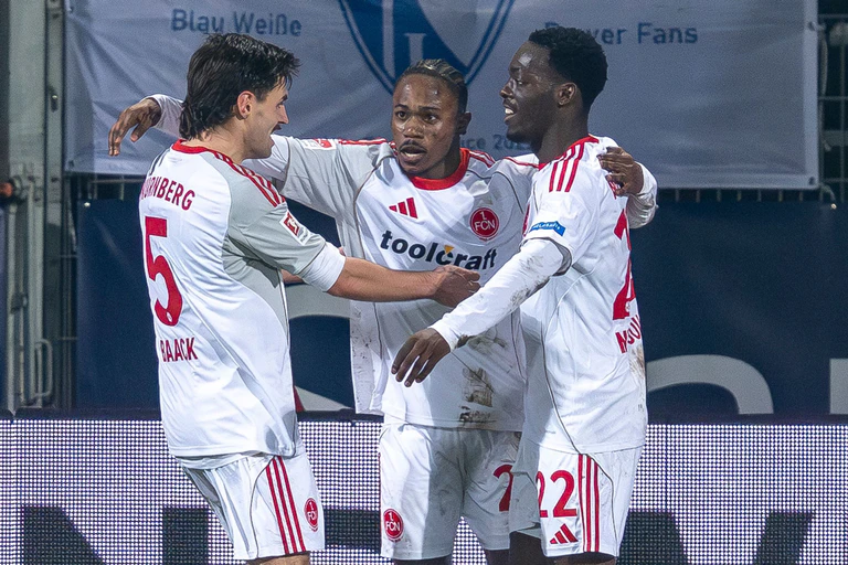 Der Nürnberger Mohamed Alì Zoma (Mitte) bejubelt mit den Vorlagengebern Tom Baack (links) und Rabby Nzingoula seinen Treffer zur 1:0-Führung. — © David Inderlied/dpa