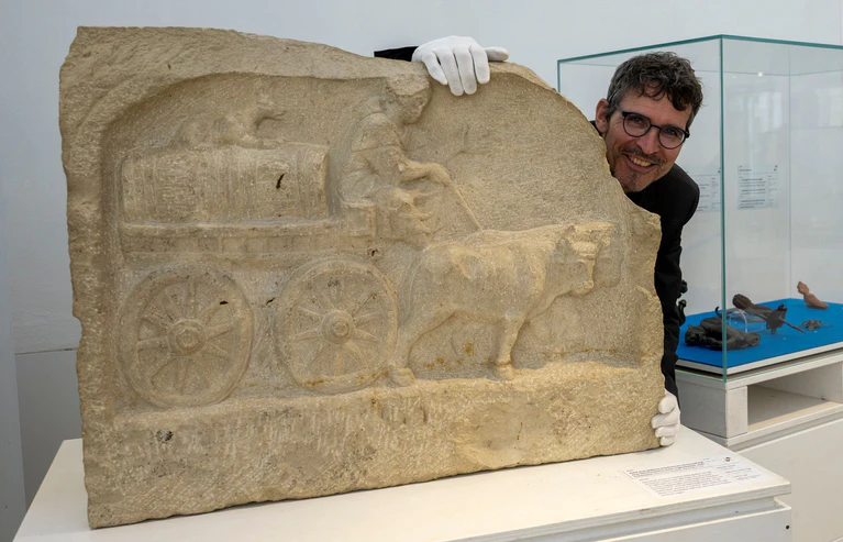 Augsburgs Stadtarchäologe Sebastian Gairhos zeigt ein römisches Grabrelief, das Ende des Jahres bei einer großen Ausstellung in Rom präsentiert werden soll. (Archivbild) — © Stefan Puchner/dpa
