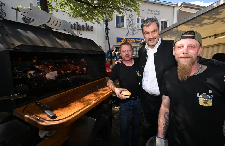 Ministerpräsident Söder am Schweinegrill.  — © Felix Hörhager/dpa