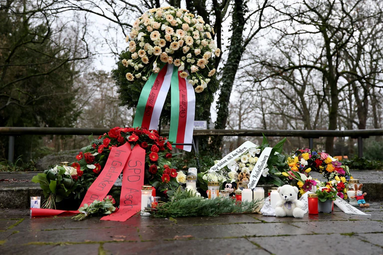 Menschen haben Blumen niedergelegt. — © Daniel Löb/dpa